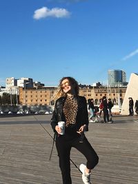 Full length of woman standing on city against sky