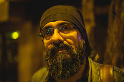Portrait of bearded man wearing eyeglasses at night