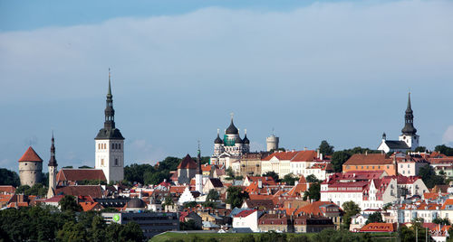 Buildings and churches in city against sky