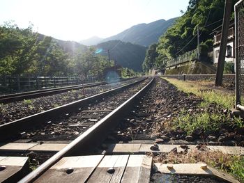 Railroad tracks against mountains on sunny day