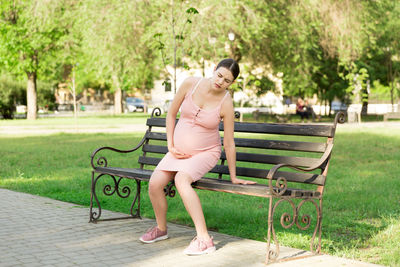 Woman sitting on bench in park