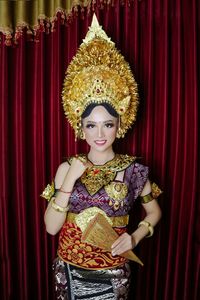 Portrait of woman wearing costume against backdrop