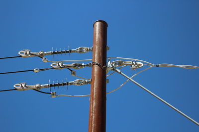 Low angle view of power lines against blue sky