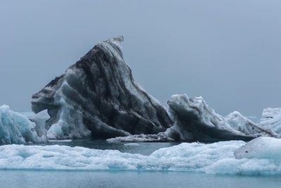 Scenic view of glaciers in sea against clear sky