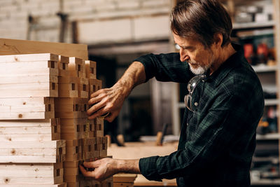 Side view of man working on wood