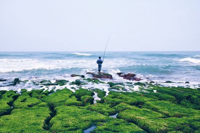 Man holding sea against clear sky