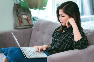 Young woman using laptop at home