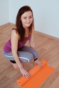 Portrait of woman sitting on hardwood floor