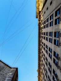 Low angle view of buildings against clear blue sky