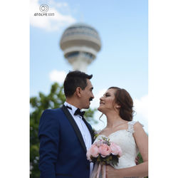 Man and woman holding camera while standing in park