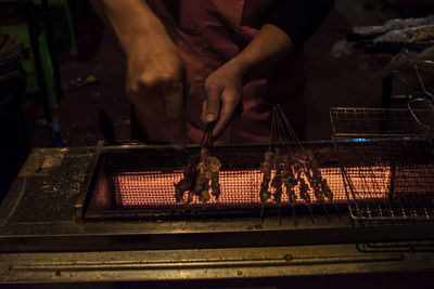 Midsection of man preparing food on barbecue grill