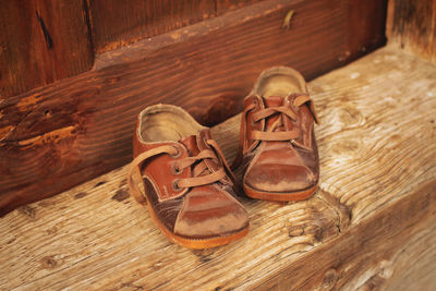 Cute baby retro shoes over wooden doorstep of old village house, retro country style