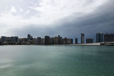 Sea by cityscape against sky