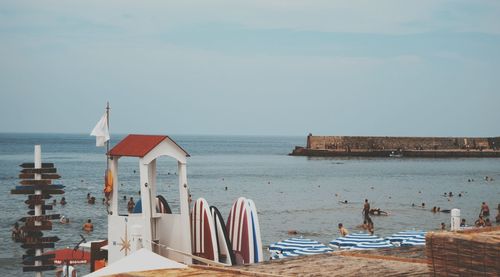 Chairs on beach by sea against sky