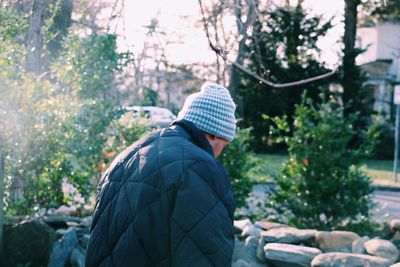 Rear view of man with umbrella against trees