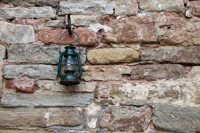 Close-up of clock hanging against brick wall