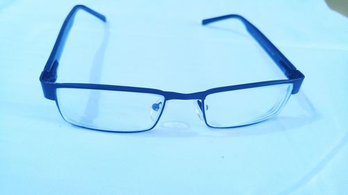 High angle view of eyeglasses on table against blue background