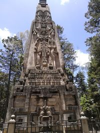 Low angle view of buddha statue against trees