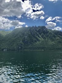 Scenic view of lake by mountains against sky