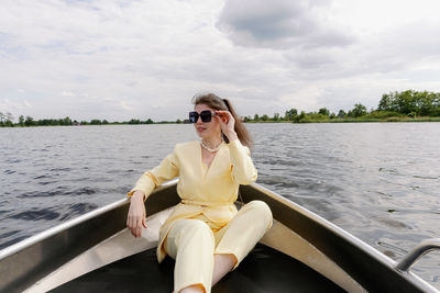 Portrait of young woman sitting in boat in lake