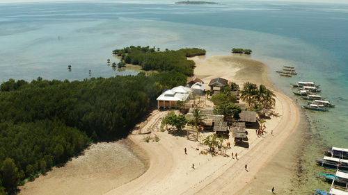 Beautiful beach on tropical island surrounded by coral reef, sandy bar with tourists. honda bay 