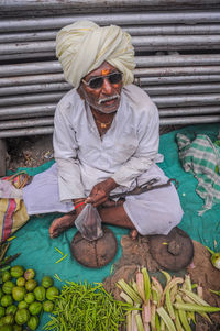 High angle view of senior man wearing sunglasses selling vegetables in market
