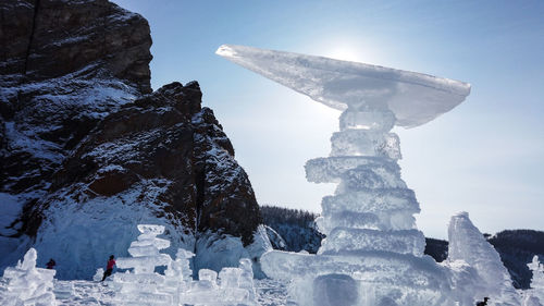 Built structure on snow covered mountain against sky