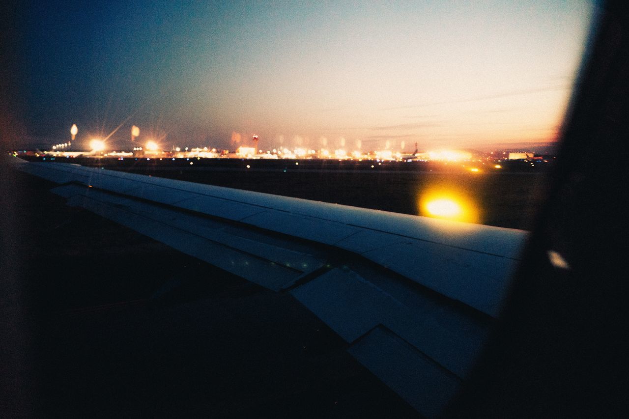 illuminated, no people, sunset, transportation, sky, night, outdoors, city, built structure, architecture, building exterior, airplane, nature, water, close-up