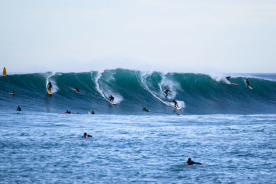 People in sea against sky