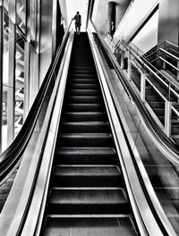 Low angle view of man standing on escalator