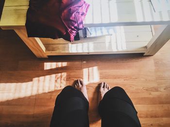 Low section of woman standing on hardwood floor