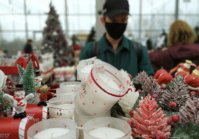 Young man wearing mask looking at christmas decoration