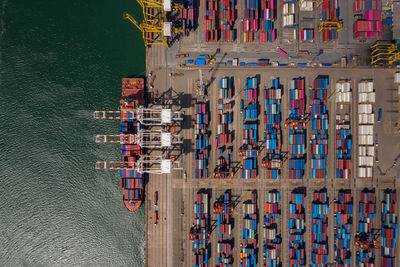 Container ship loading and unloading in sea port, aerial view of business logistic import and export 