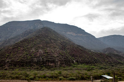 Scenic view of mountain range against cloudy sky