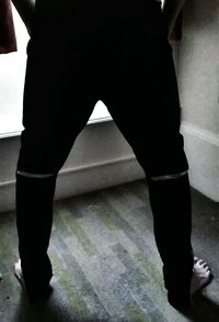 Low section of man standing on tiled floor