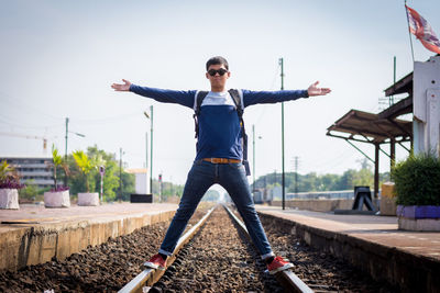 Full length of man with arms raised against sky