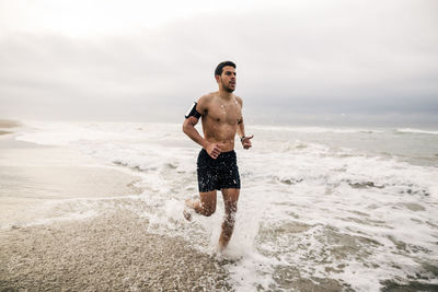 Young man running in the sea