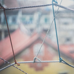 Close-up of rope tied to metal fence