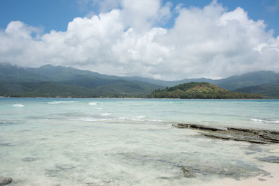 Scenic view of sea and mountains against sky