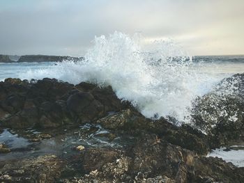 View of waves breaking on rocky shore