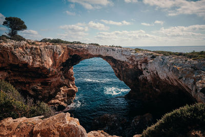 Rock formations by sea against sky