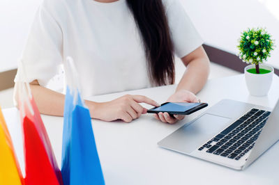 Midsection of woman using laptop on table