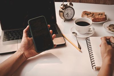 Hand holding coffee cup on table