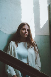 Portrait of woman standing against wall