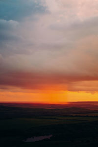 Scenic view of silhouette landscape against orange sky