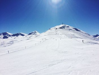 Scenic view of snowcapped mountains against clear blue sky