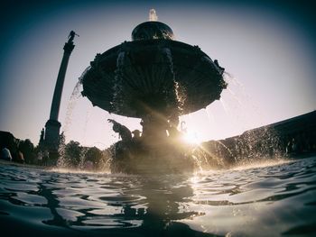 Low angle view of fountain in swimming pool against sky