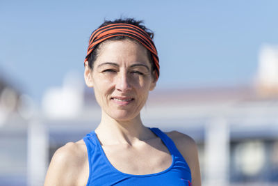 Portrait of mature woman standing against clear sky