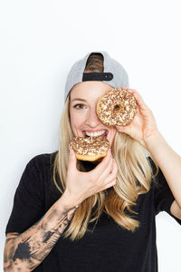 Portrait of a smiling young woman holding ice cream over white background