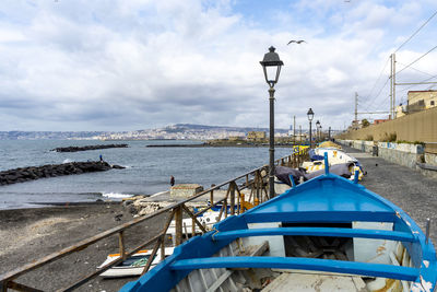 Nautical vessel on sea by buildings against sky